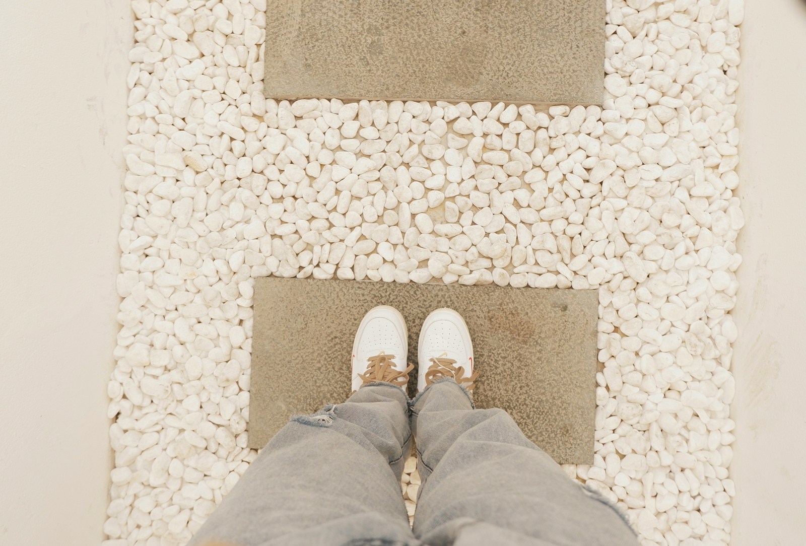 a person standing in front of a rug with pebbles on it